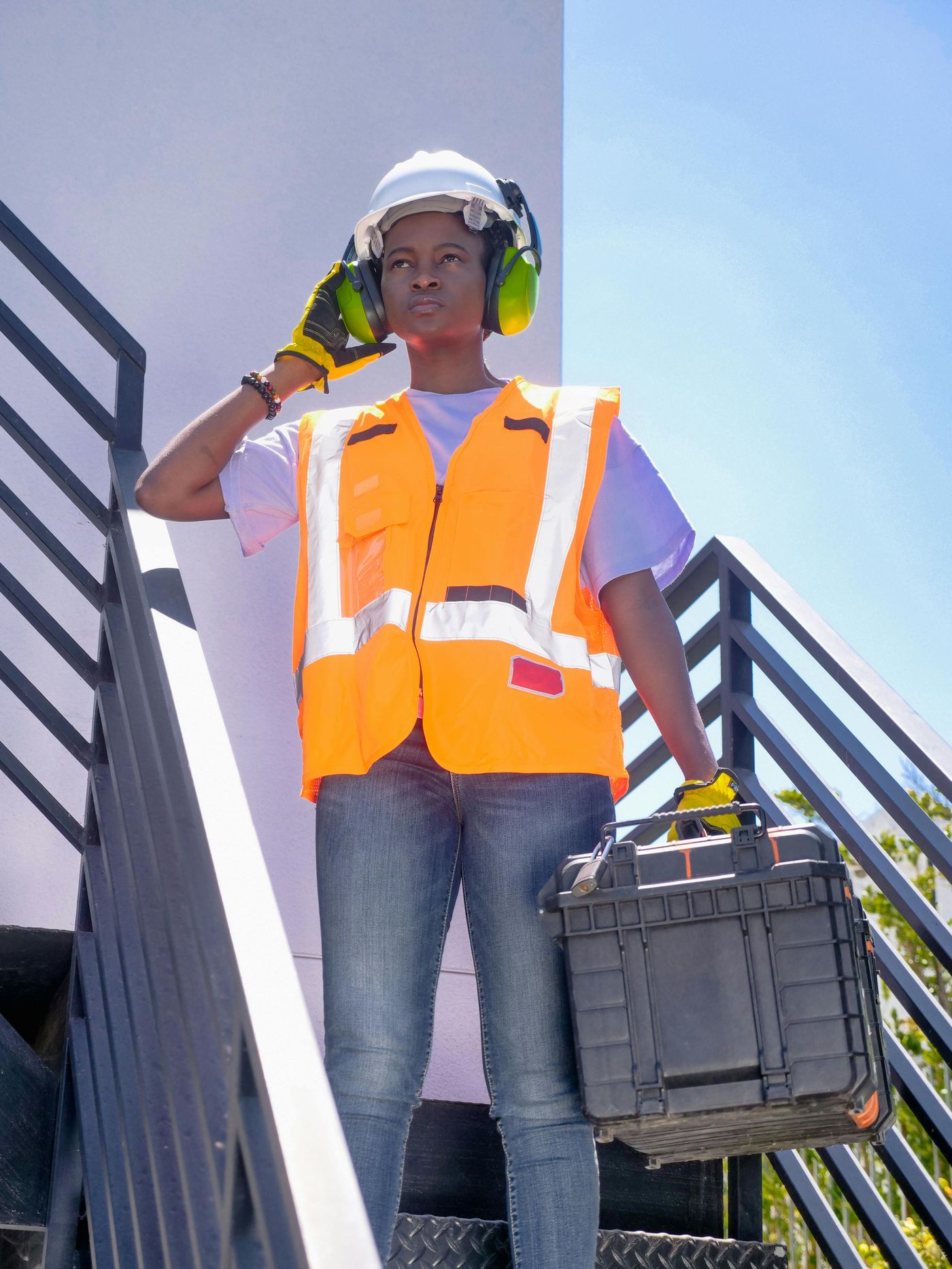 Construction workers wearing complete PPE safety equipment including helmets and high-visibility vests